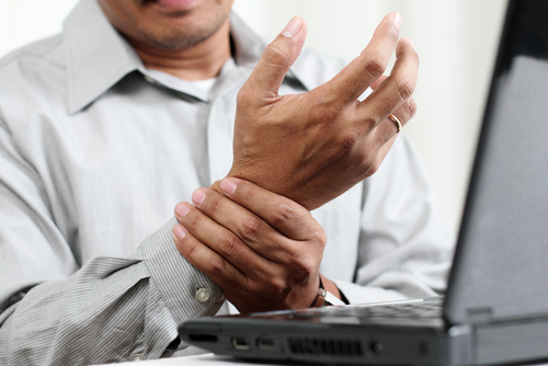 Carpal tunnel workers comp: man holding his painful wrist