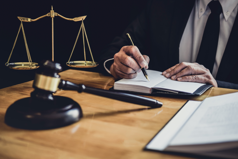 New York Workers' Compensation lawyer working at desk on paperwork with gavel and justice scale