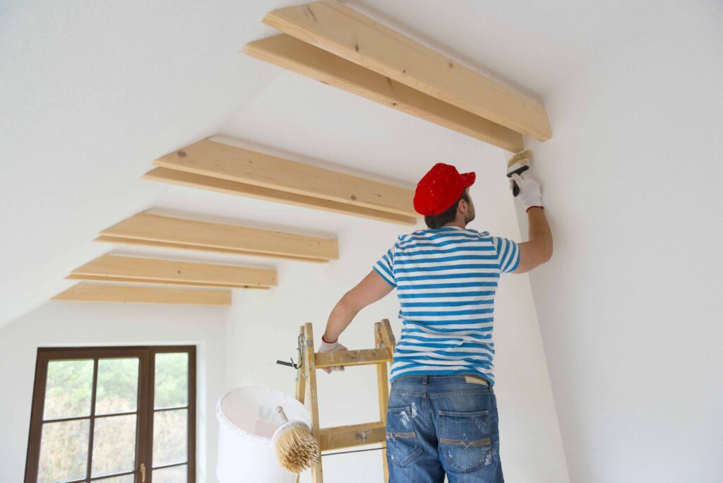 Man on ladder using lead based paint before calling a New York Workers' Compensation lawyer