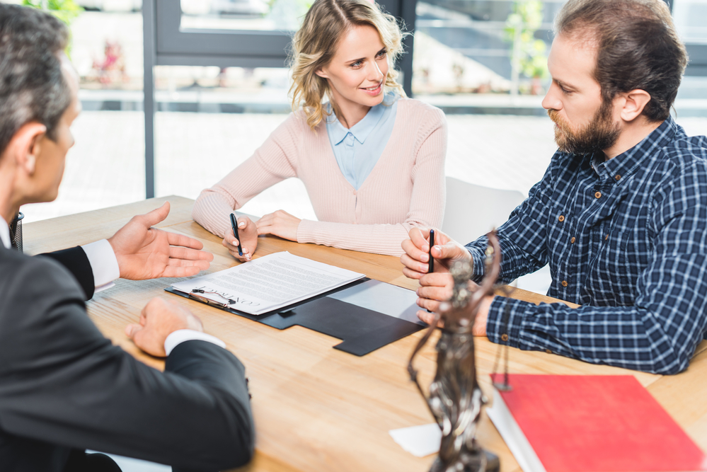Man and woman consult with a New York Workers' Compensation lawyer at their desk