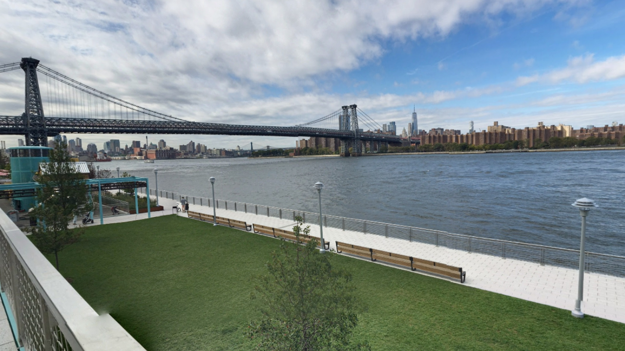 Water, green area, and bridge at Domino Park Brooklyn NY